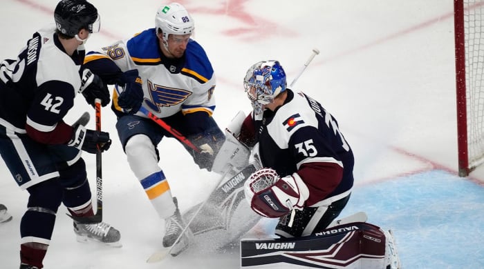 St. Louis Blues left wing Pavel Buchnevich, center, has his shot stopped by Colorado Avalanche goaltender Darcy Kuemper, right, after driving past defenseman Josh Manson in the first period of an NHL hockey game Tuesday, April 26, 2022, in Denver.
